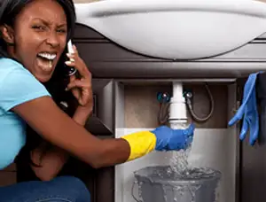Emergency plumbing repair for a leaking sink drain under a bathroom vanity in Olathe, KS