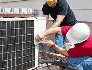HVAC technicians repairing an outdoor AC unit on a rooftop in Olathe, KS