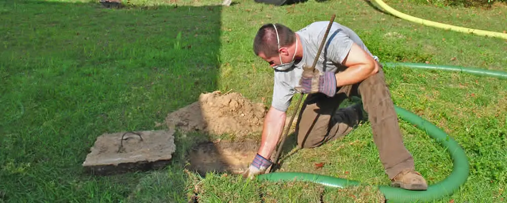 Septic pumping technician servicing a residential septic tank in Olathe, KS